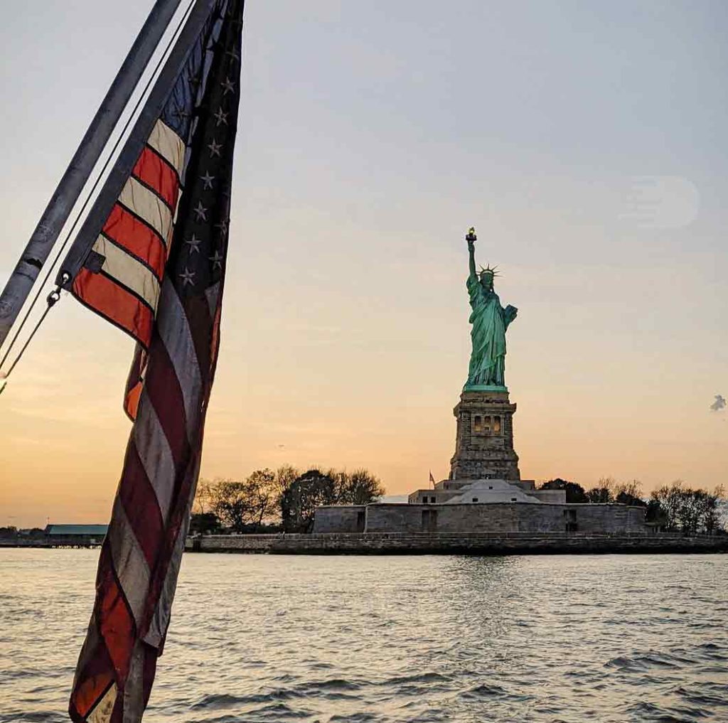 American Flag in foreground with Statue of Liberty in the background