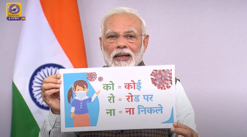 PM Narendra Modi holds a picture to explain the lockdown