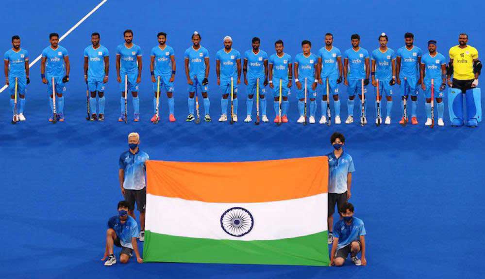 Indian team with the national flag after winning the Bronze at Tokyo Olympics