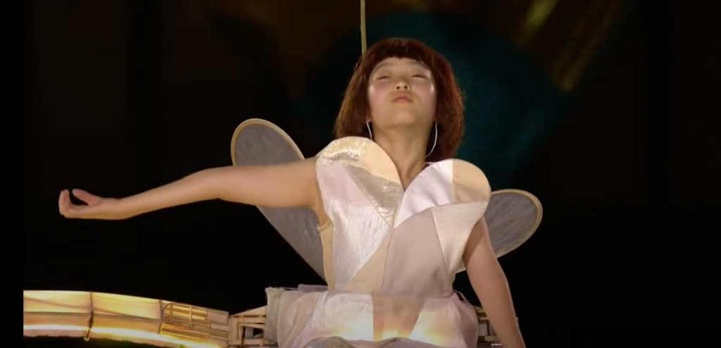 A Japanese girl plays the role of one winged plane at the Tokyo Paralympics