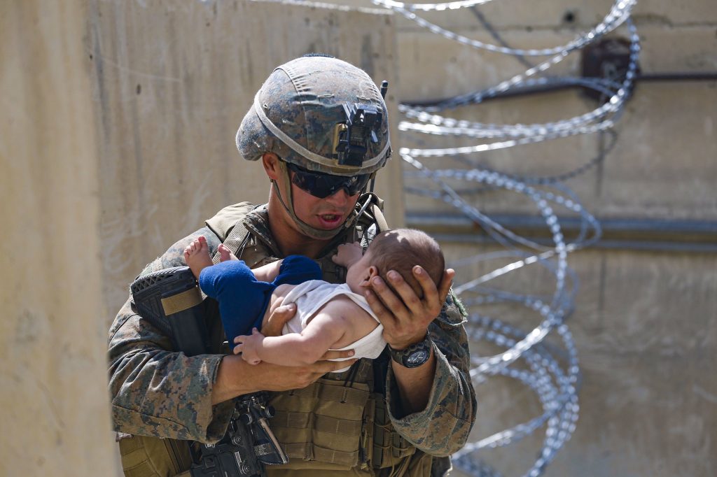 A US soldier comforts a Afghan baby at Kabul Airport