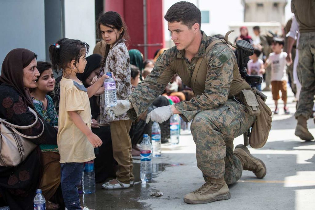 A US Soldier offers drinking water to a child