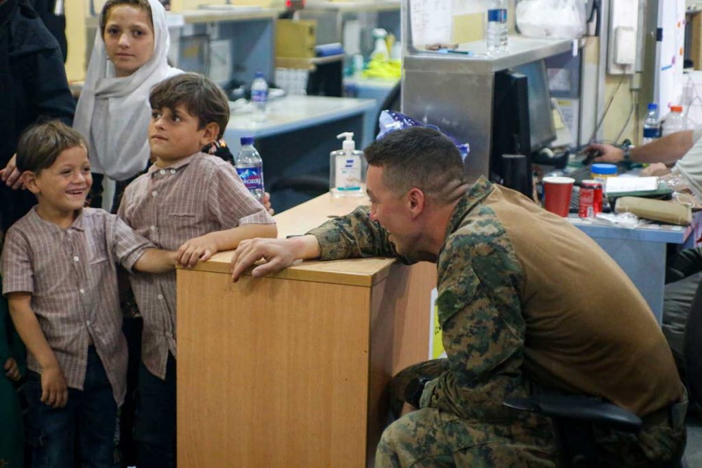 A US Soldier shares a laugh with an Afghan child as their case is being processed