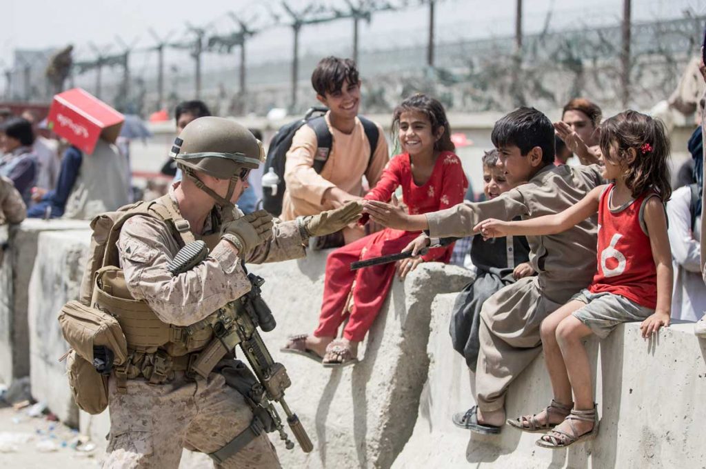 A US Marine plays with a group of Afghan kids