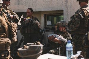US troops comfort infants at Kabul Airport while their families await processing