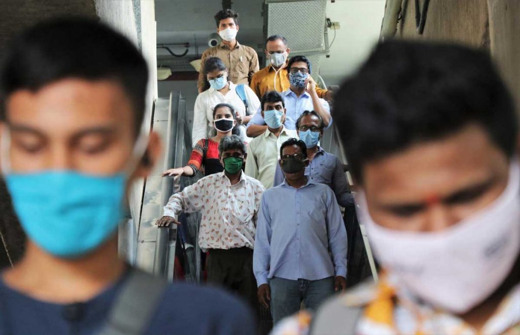 Commuters wear masks at a metro station in India