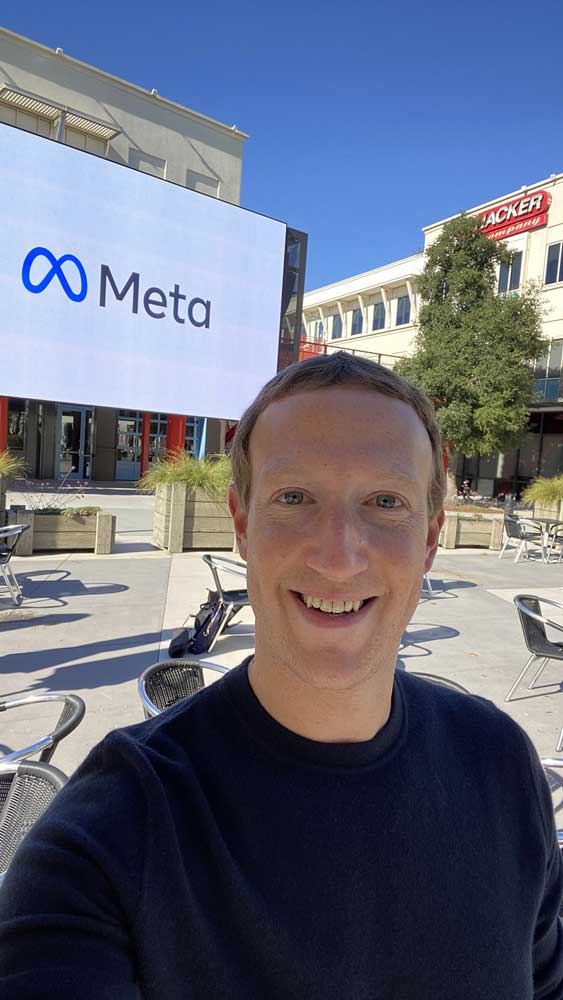Mark Zuckerberg in front of Meta Symbol