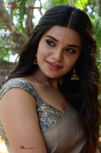 Telugu and Tamil actress Aathmika posing in a Grey Saree