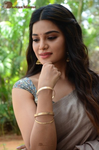 Telugu and Tamil actress Aathmika posing in a Grey Saree