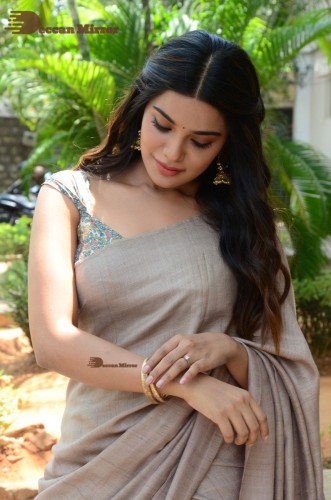 Telugu and Tamil actress Aathmika posing in a Grey Saree