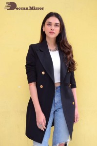 Aditi Rao pictures in white top, blue jeans and black overcoat
