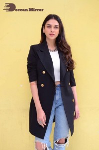 Aditi Rao pictures in white top, blue jeans and black overcoat