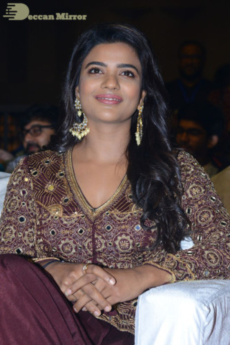 Actress Aishwarya Rajesh posing for a photoshoot in a dark brown dress
