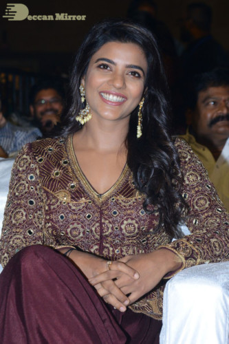 Actress Aishwarya Rajesh posing for a photoshoot in a dark brown dress