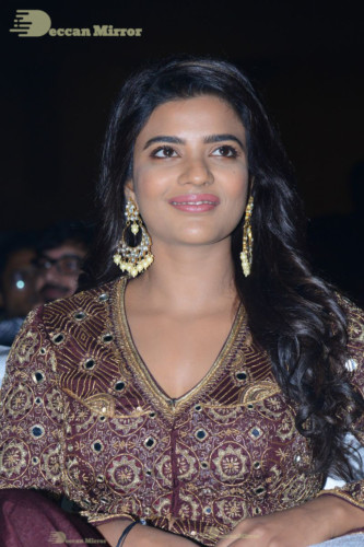 Actress Aishwarya Rajesh posing for a photoshoot in a dark brown dress