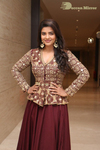 Actress Aishwarya Rajesh posing for a photoshoot in a dark brown dress