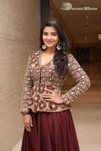 Actress Aishwarya Rajesh posing for a photoshoot in a dark brown dress