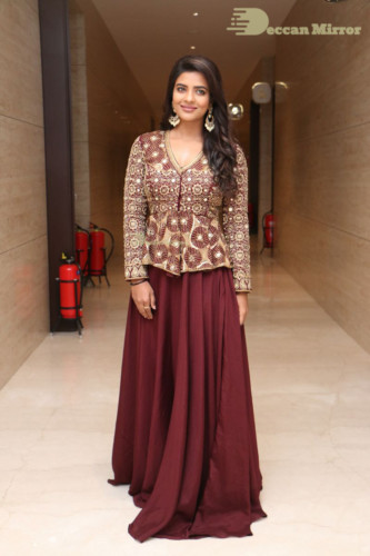 Actress Aishwarya Rajesh posing for a photoshoot in a dark brown dress