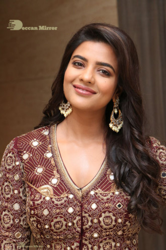 Actress Aishwarya Rajesh posing for a photoshoot in a dark brown dress