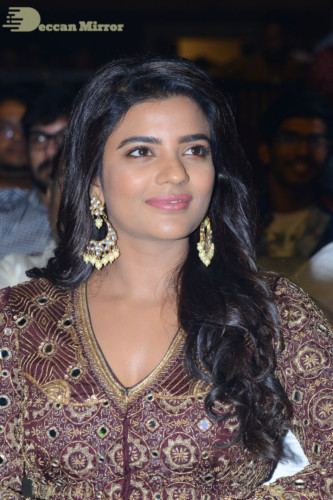 Actress Aishwarya Rajesh posing for a photoshoot in a dark brown dress