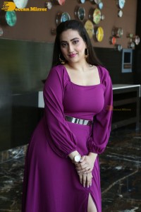 Anchor Manjusha in a purple dress posing for pictures
