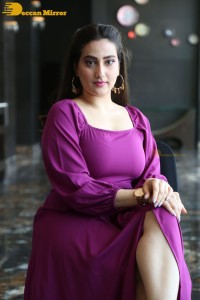 Anchor Manjusha in a purple dress posing for pictures