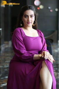 Anchor Manjusha in a purple dress posing for pictures