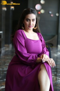 Anchor Manjusha in a purple dress posing for pictures