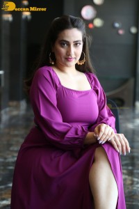 Anchor Manjusha in a purple dress posing for pictures