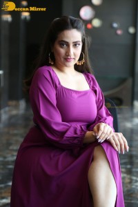 Anchor Manjusha in a purple dress posing for pictures