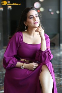 Anchor Manjusha in a purple dress posing for pictures