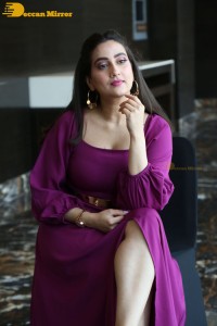 Anchor Manjusha in a purple dress posing for pictures