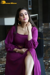 Anchor Manjusha in a purple dress posing for pictures
