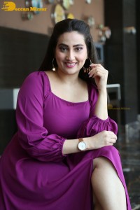 Anchor Manjusha in a purple dress posing for pictures