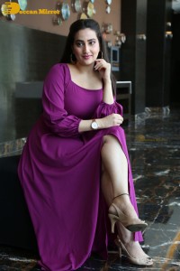Anchor Manjusha in a purple dress posing for pictures