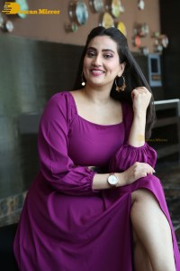 Anchor Manjusha in a purple dress posing for pictures