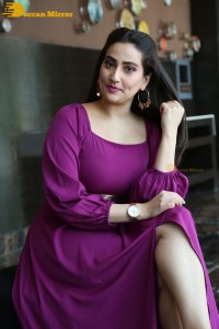 Anchor Manjusha in a purple dress posing for pictures