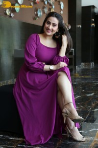 Anchor Manjusha in a purple dress posing for pictures