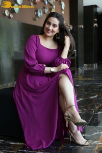 Anchor Manjusha in a purple dress posing for pictures