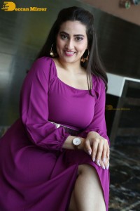 Anchor Manjusha in a purple dress posing for pictures
