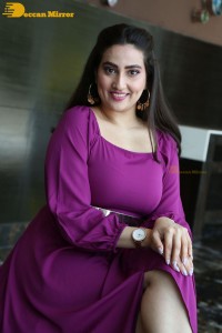 Anchor Manjusha in a purple dress posing for pictures