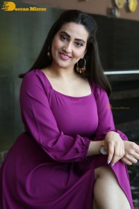 Anchor Manjusha in a purple dress posing for pictures