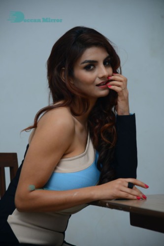 Actress Anveshi Jain posing for pictures in a blue dress