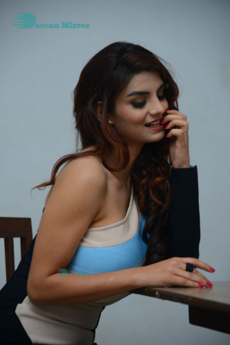 Actress Anveshi Jain posing for pictures in a blue dress