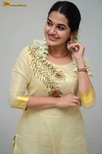 actress aparna janardanan cute looks in a light yellow salwar kameez