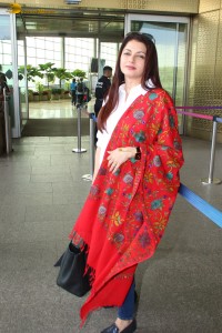 actress Bhagyashree in a white shirt and red shawl looking classy at the airport