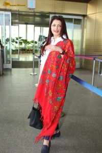 actress Bhagyashree in a white shirt and red shawl looking classy at the airport