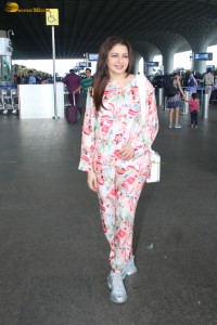 actress bhagyashree in a white and pink floral dress at airport