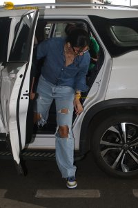 Indian model and actress Daisy Shah in a blue shirt and jeans at mumbai airport