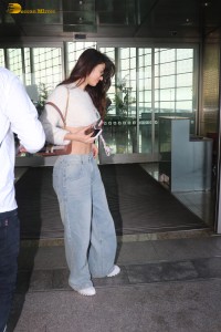 actress Disha Patani in a white top and denim jeans